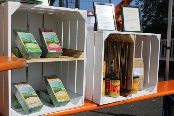 KI generiert: Verschiedene Lebensmittelprodukte in Holzkisten ausgestellt, darunter Falafel-Mix und Gläser mit Aufstrichen.