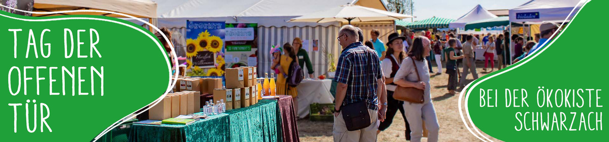 KI generiert: Menschen besuchen Marktstände im Freien. Text: "TAG DER OFFENEN TÜR BEI DER ÖKOKISTE SCHWARZACH".