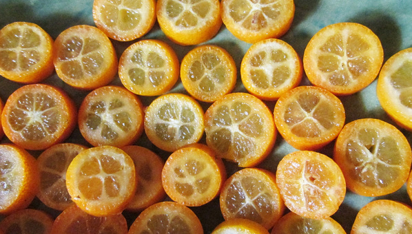 KI generiert: Mehrere halbierte Kumquats liegen dicht beieinander auf einer Oberfläche.
