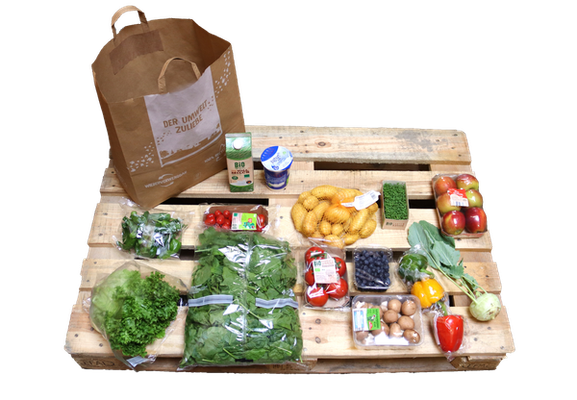 Ökokisten-Auto von früher, Schwarzacher Kloster Türme im Hintergrund. Veit Plietz beim Einladen des Transporters mit grünen Mehrwegkisten.